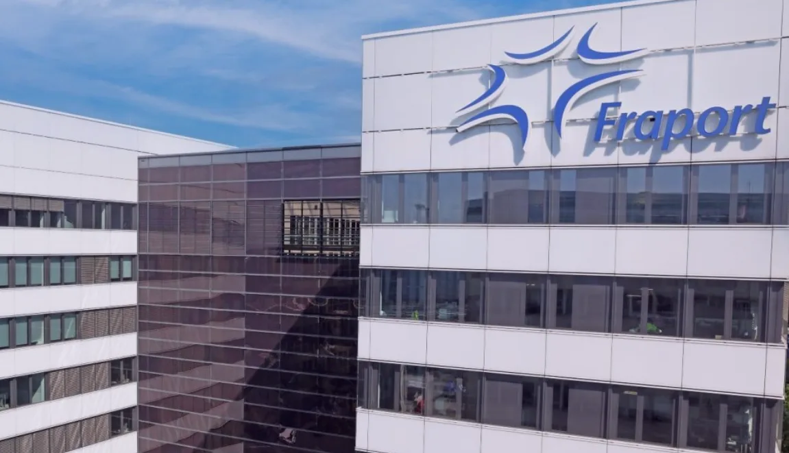 Fraport Konzernzentrale Gebäude mit Firmenlogo an Bürofassade und gläsernem Verbindungsbau unter blauem Himmel