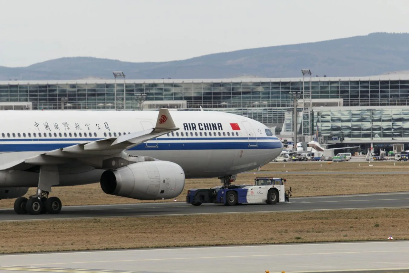 Air China Flugzeug an Schlepper am Flughafen Frankfurt vor Terminalgebäude