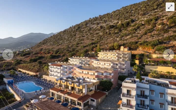 Hotelanlage mit Pool vor bewaldetem Hang in Koni Village nahe Stalis, Griechenland, Ferienunterkunft am Meer, Sonnenliegen und Apartmentbalkone