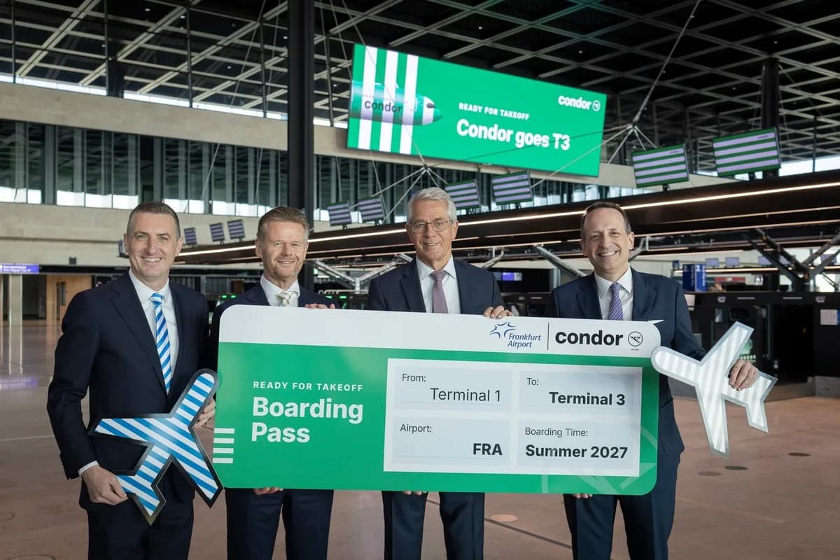 Vier Männer in Anzügen halten am Flughafen Frankfurt im neuen Terminal 3 ein übergroßes grünes Boarding-Pass-Display mit Condor-Logo zur Ankündigung des Terminal-Wechsels.