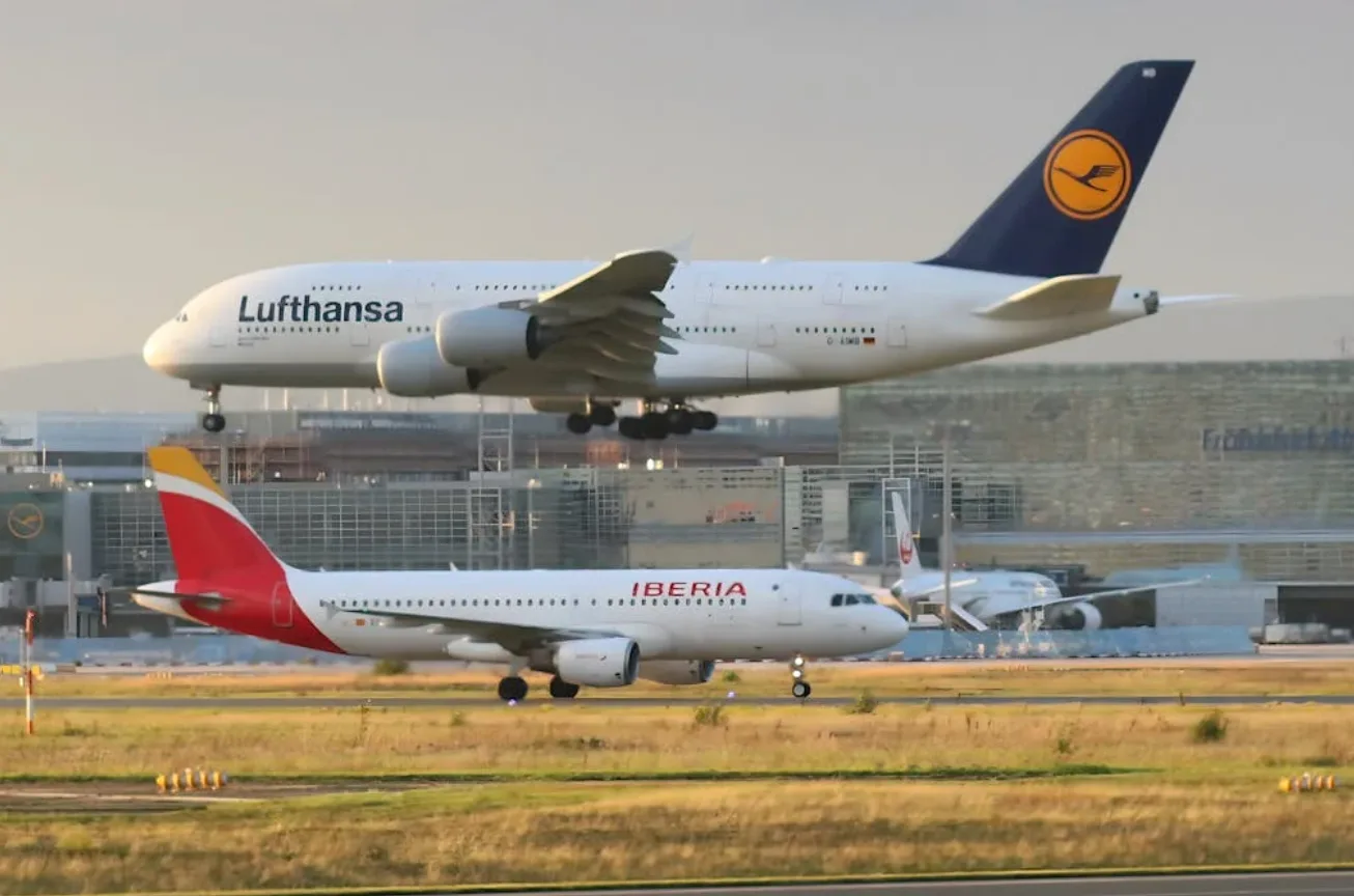 Lufthansa A380 im Landeanflug über Taxiway mit wartendem Iberia-Flugzeug am Flughafen Frankfurt, Reise- und Parkhotel ParkSleepFly Szene