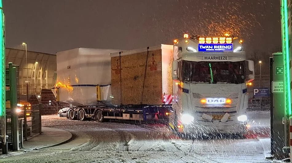 Lkw-Zug mit übergroßer Boeing-777-Simulationskabine auf Tieflader bei Schneefall am Hafen in Frankfurt, beleuchteter Fernfahrer-Lkw mit Warnlichtern und Planenladung (c) Bild LAT