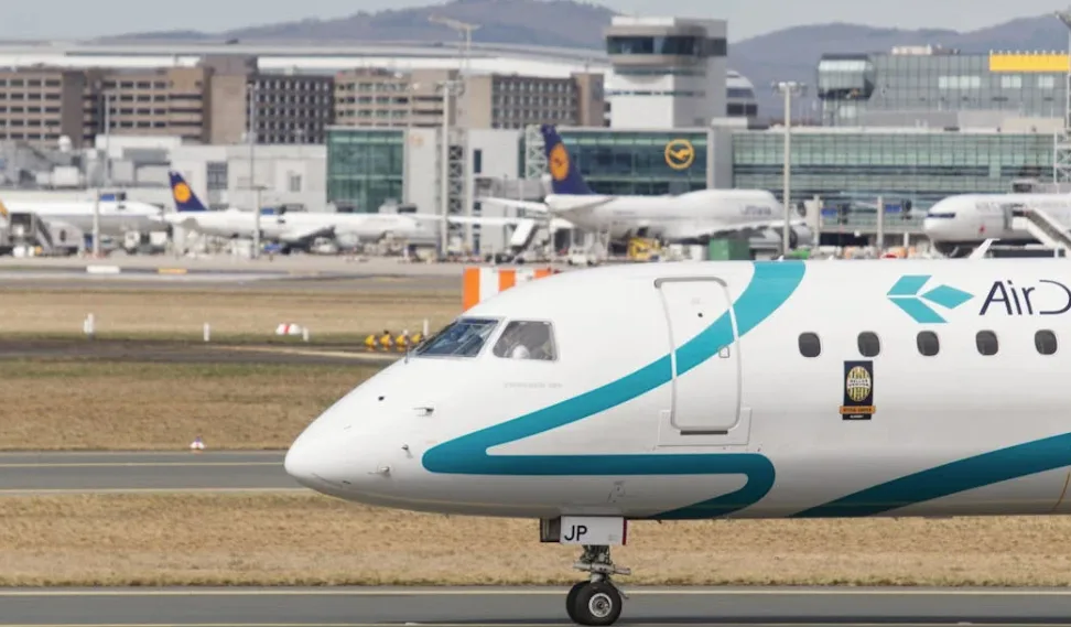 Air Dolomiti Regionaljet am Flughafen Frankfurt Taxiing mit Terminal im Hintergrund, Bezug zur Strecke Frankfurt–Ljubljana