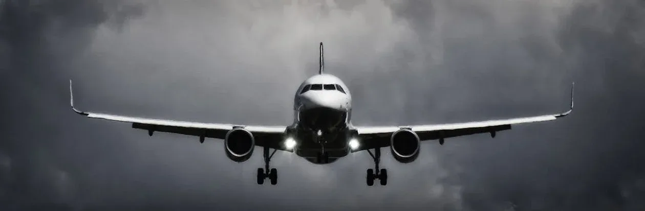 Passagierflugzeug im Landeanflug vor dramatischem Wolkenhimmel, frontalaufnahme mit ausgefahrenem Fahrwerk am Flughafen Frankfurt