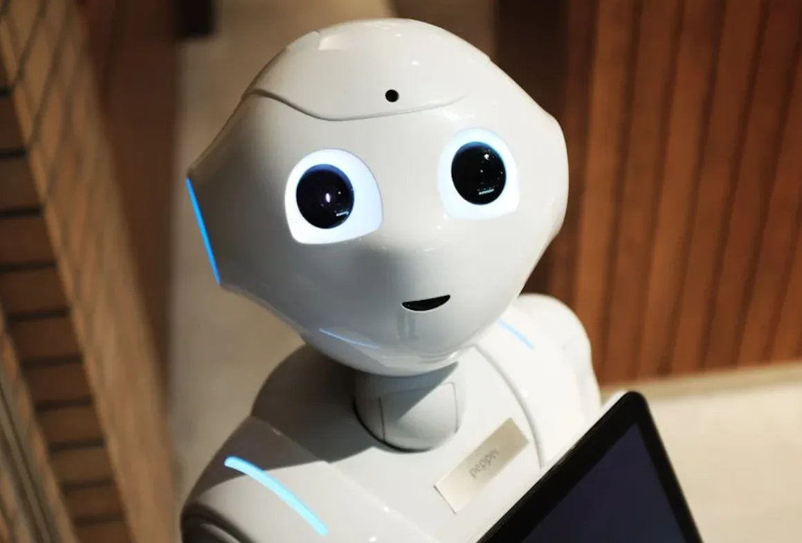 weißes Serviceroboter-Gesicht mit leuchtenden Augen und Display im Innenbereich, futuristische Reisetechnologie und Hospitality-Trend