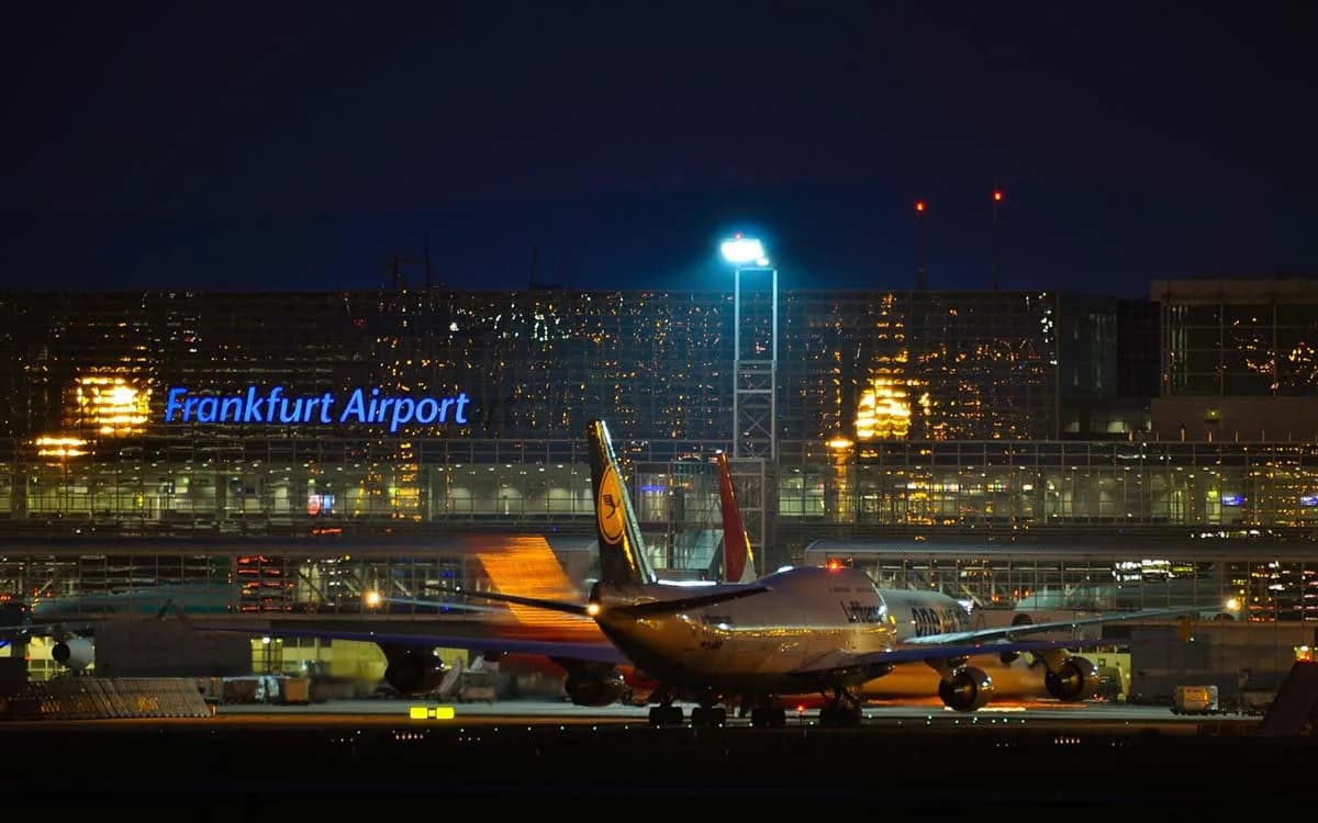 Flugzeuge am Abend vor beleuchtetem Terminal Frankfurt Airport mit geparkten Langstreckenjets