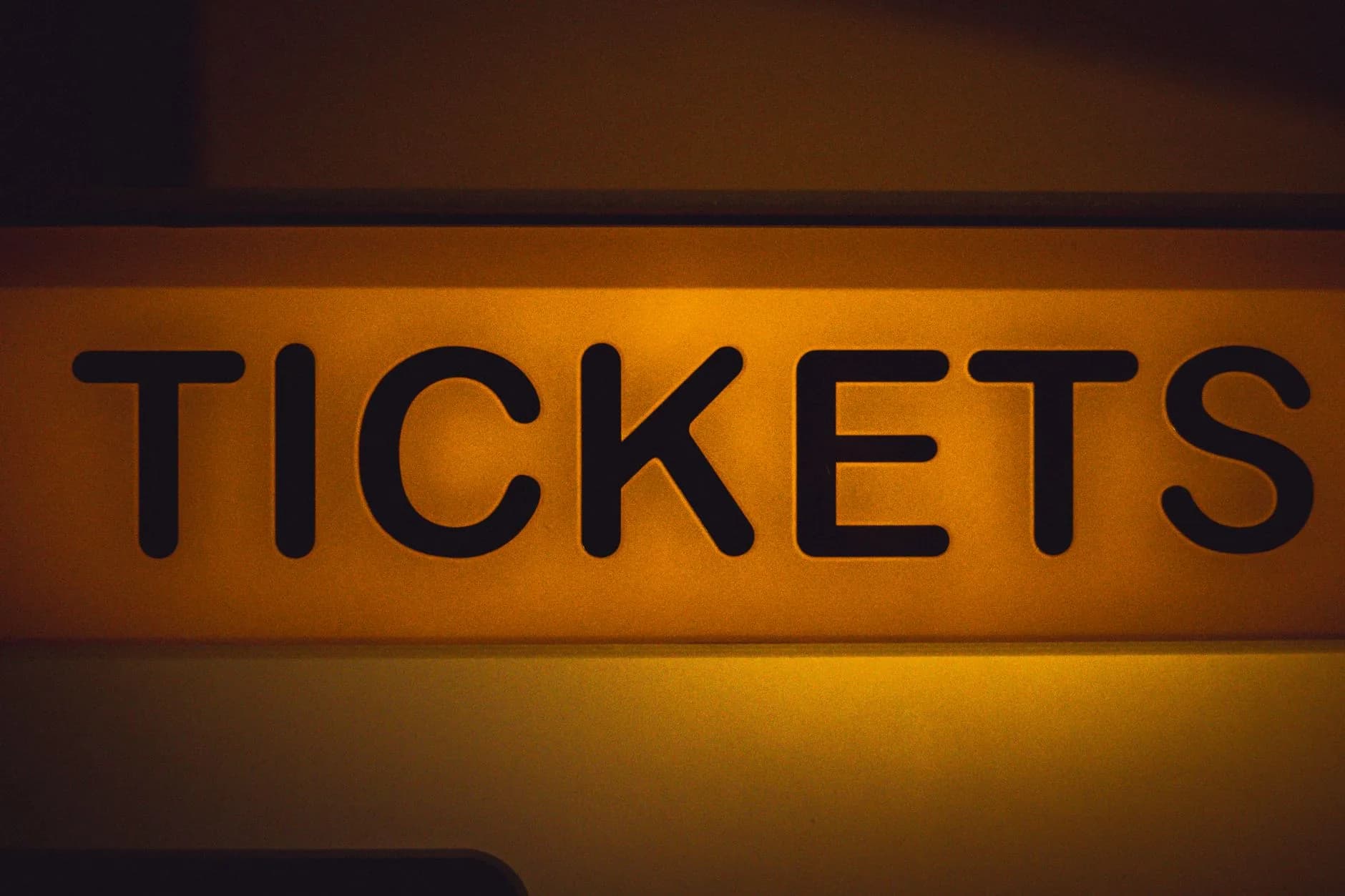 Beleuchtetes Schild mit der Aufschrift Tickets in schwarzen Buchstaben auf gelbem Grund