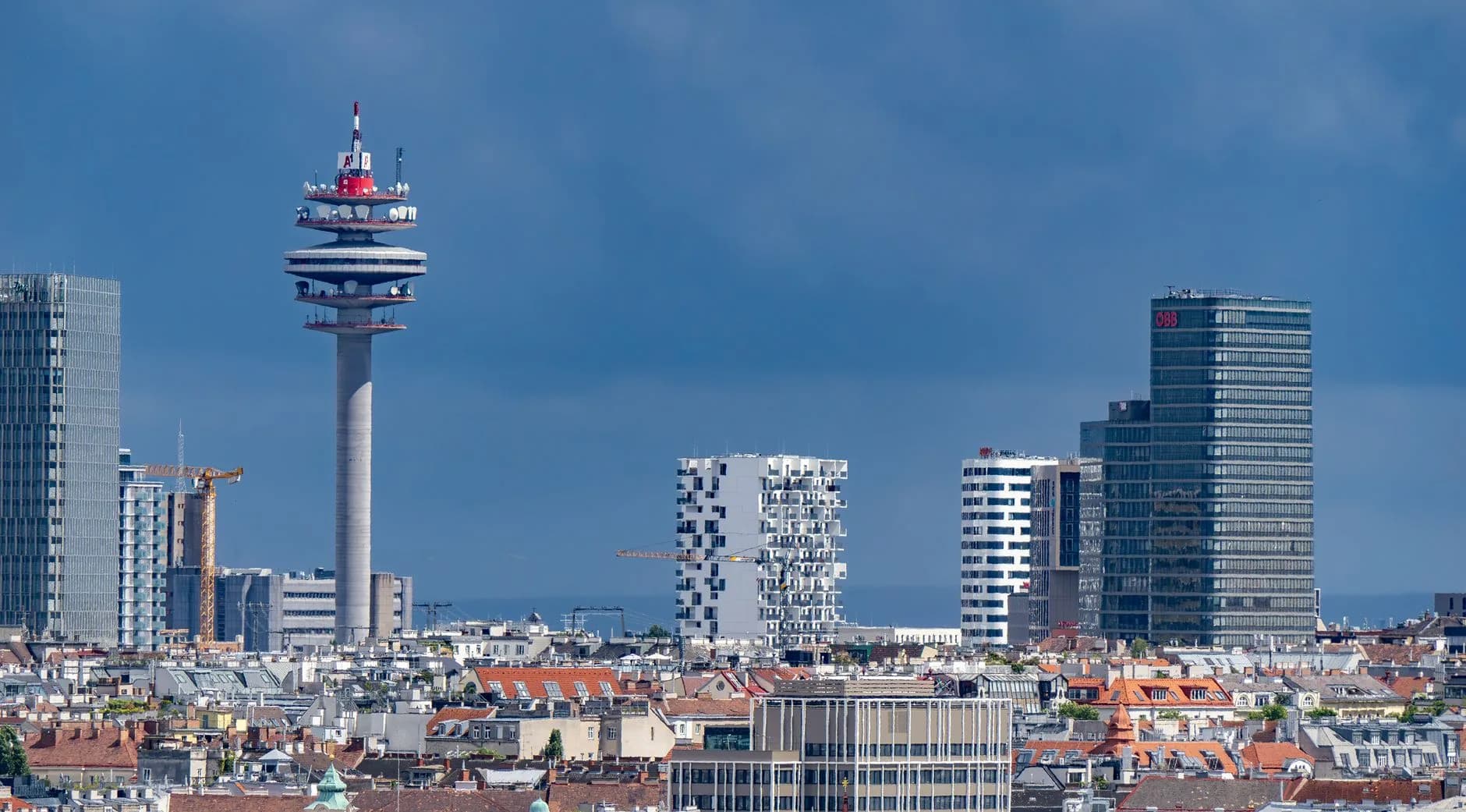 Skyline mit Fernsehturm und Hochhäusern über den Dächern der Altstadt vor blauem Himmel