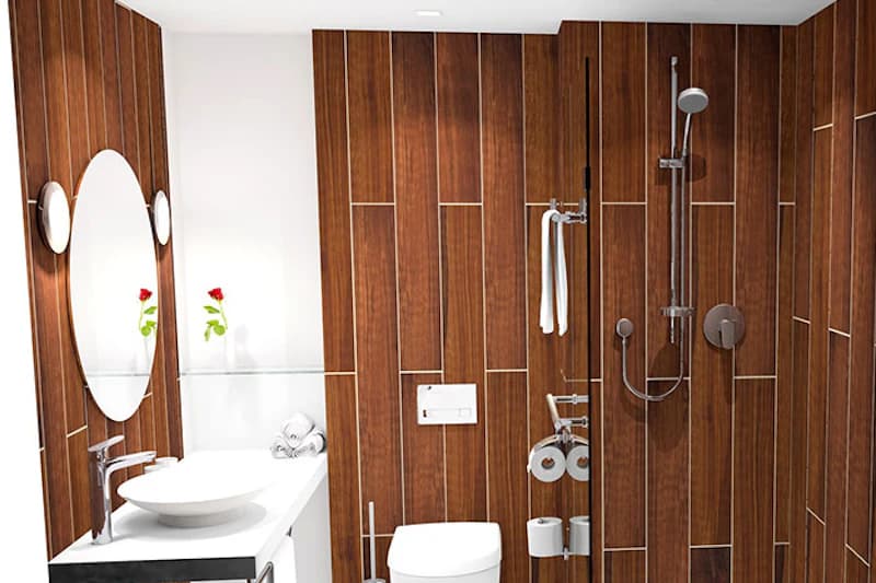Hotelbadezimmer mit Holzfliesen, Waschbecken, runder Spiegel, Toilette und Dusche mit Glasabtrennung.