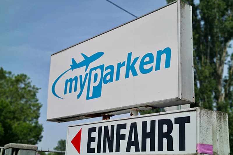 Weißes Schild mit blauem myparken-Logo und darunter ein Einfahrt-Schild mit rotem Pfeil.