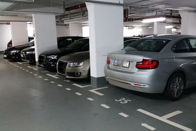 Tiefgarage mit markierten Stellplätzen, Säulen und mehreren geparkten Pkw; Bodenmarkierung Nummer 35 sichtbar.